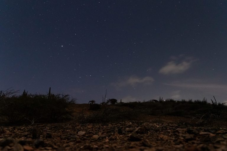 Hiking under the starry night sky on the way to Aruba's Natural Pool